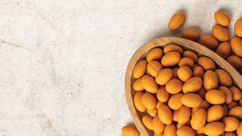 Golden brown crispy peanuts moving on a professional cooling conveyor.